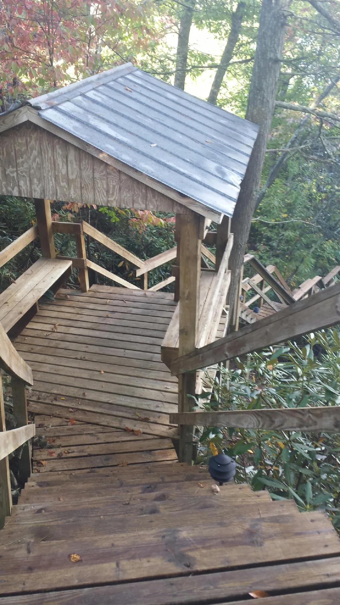 Metal roofed shelter over wooden steps on a wooded walkway — Skylight Repair & Installation work by our crew in Leeds
